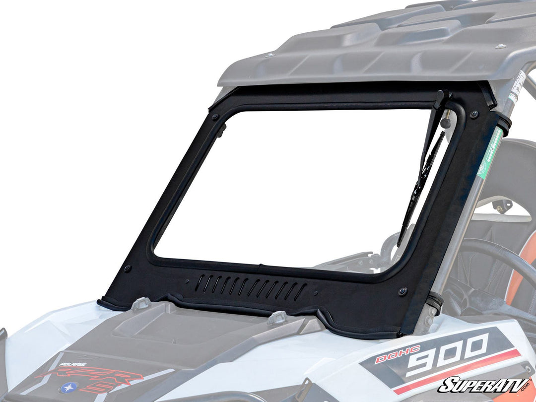 Close-up of a SuperATV Polaris RZR XP 1000 Glass Windshield installed on a UTV, showing the robust aluminum frame and manual wiper, highlighting the lightly tinted glass and vent for airflow control.